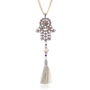 Macro shot of Hamsa hand pendant with brown rhinestones and long silk tassels