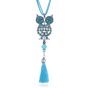 Dettaglio del ciondolo a forma di gufo con strass blu cielo e nappine lunghe eleganti