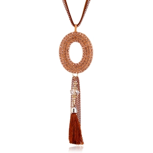 Dettaglio della collana lunga con nappa, strass marroni e perla di cristallo lucida