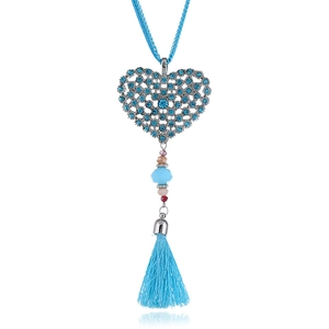 Detail of heart pendant with blue rhinestones and light blue silk tassel on long necklace