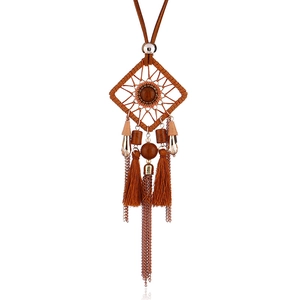 Détail du collier attrape-rêves bohème avec cordon en daim marron et goutte d'ambre