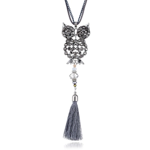Dettaglio macro della collana a gufo con strass scuri, perle di cristallo e lunghe frange