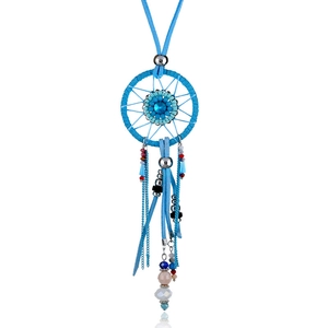 Macro view of blue dreamcatcher pendant with faceted gem, suede tassels, and colorful beads