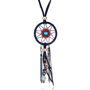 Detail of bohemian dreamcatcher necklace with blue gemstone and colorful beaded tassels