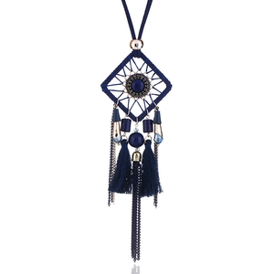 Détail du collier attrape-rêves bohème avec pompons bleu foncé et accents en métal doré