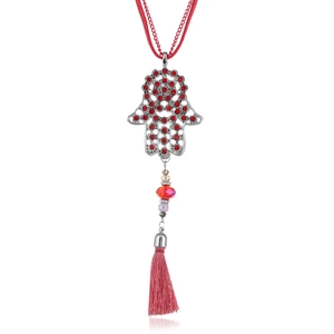 Detailed view of Hamsa Hand pendant with red rhinestones and pink silk tassel decoration