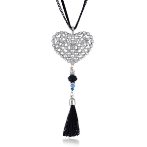 Detail of silver heart pendant with rhinestones, colorful beads, and black fabric tassel