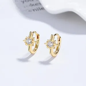 Macro detail of gold S925 sterling silver star hoop earrings with sparkling zircon stones