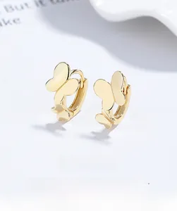 Close-up of golden butterfly hoop earrings with a minimalist double-butterfly design