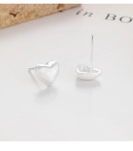 Macro view of S925 sterling silver heart earrings with a brushed matte metallic texture