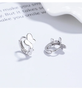 Macro detail of S925 sterling silver hoop earrings with delicate double butterfly design