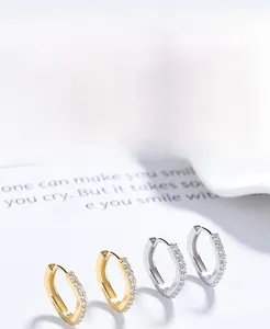 Macro detail of gold and silver S925 sterling silver hoop earrings with geometric zircons