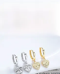 Détail de boucles d'oreilles cœur en argent S925 avec texture scintillante effet glace