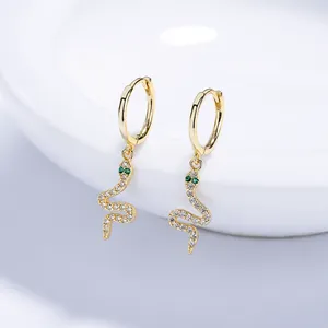 Elegante gouden slangenoorbellen met witte kristallen en groene edelstenen ogen