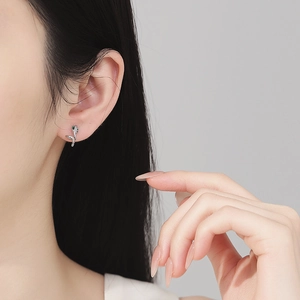 S925 silver snake stud earrings with emerald eyes and sparkling zircon pavé on model