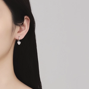 Boucles d'oreilles cœur en argent S925 avec zircons micro-pavés sur un modèle