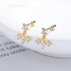 Macro view of gold S925 silver stud earrings with zircon drops and screw back closure