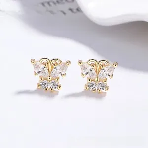 Détail de boucles d'oreilles papillon dorées avec zircons taille marquise et ronde