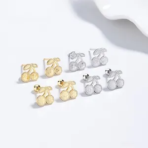 Detailed view of cherry-shaped 925 silver stud earrings in gold and silver matte finish