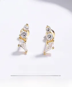 Macro shot of geometric gold earrings with cubic zirconia and screw back closure