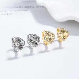 Detail of four-leaf clover earrings with metallic texture and pavé-set stones