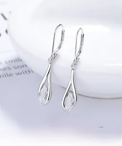 Close-up of S925 silver marquise-cut crystal earrings on a white ceramic dish