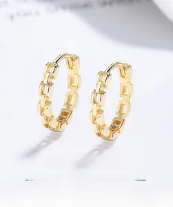 Macro shot of gold S925 sterling silver hoop earrings with a trendy tank chain link design
