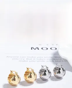 Macro detail of S925 sterling silver hammered ball earrings in gold and silver finish