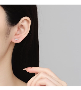 Close-up of S925 silver geometric stud earring with sparkling cubic zirconia on ear