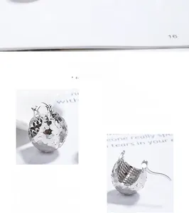 Detailed close-up of S925 sterling silver hollow sphere earrings with textured fish scale pattern