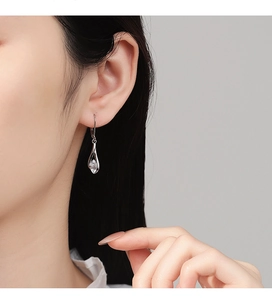 Detail of S925 silver teardrop earring with marquise zirconia on female model