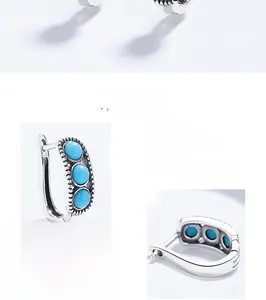 Macro detail of vintage S925 silver hoop earrings with three inlaid turquoise stones