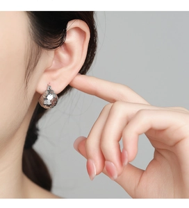 Close-up of S925 sterling silver hoop earrings with hammered texture on model