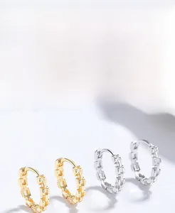 Macro detail of S925 sterling silver chain earrings in gold and silver finishes