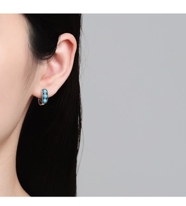 Detail view of S925 sterling silver hoop earrings with three turquoise stones on ear