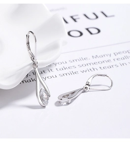 Macro shot of silver leverback earrings with marquise-cut cubic zirconia on ceramic surface