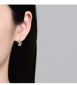 Vue détaillée des boucles d'oreilles chat en argent avec émail portées par un mannequin