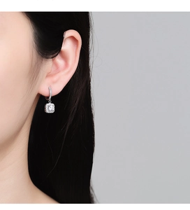 Macro detail of silver S925 square cubic zirconia drop earrings worn by a model