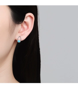 Close-up of S925 sterling silver earring with turquoise bead on a female model