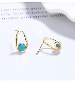 Detail view of vintage S925 silver stud earrings with oval gold frame and turquoise stone