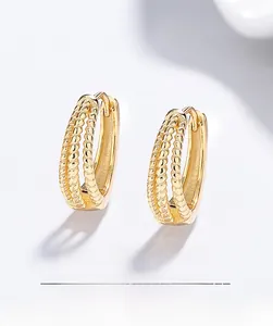 Détail de créoles torsadées à trois couches en argent 925 avec finition en or 18 carats