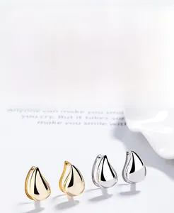 Macro shot of gold and silver S925 sterling silver teardrop earrings with a mirror finish