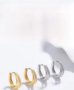 Détail macro de boucles d'oreilles créoles torsadées triple rang en argent 925
