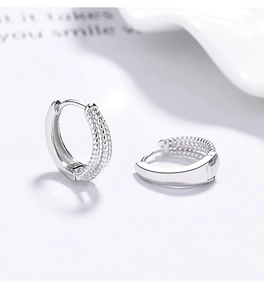 Gros plan de boucles d'oreilles en argent avec texture tressée à trois rangées de billes