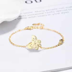 Detail of a gold butterfly necklace with zircon accent on a delicate curb chain