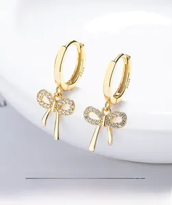 Close-up of S925 sterling silver bow earrings with micro-pave zirconia in gold finish