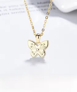 Close-up of golden butterfly pendant necklace with embossed dotted wing details