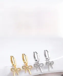 Detailed view of S925 sterling silver bow earrings in gold and silver with cubic zirconia