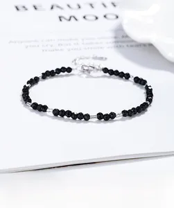 Macro shot of minimalist black bead bracelet with silver spacers and lobster clasp detail