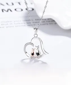Close-up of 925 sterling silver heart pendant with black and rose gold cat details